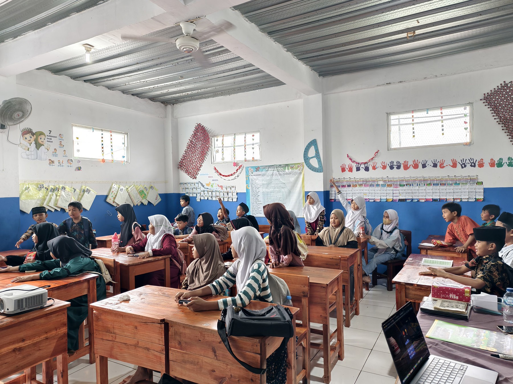 Students seated at wooden desks during an Abhipraya classroom session
